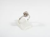 an image of a diamond and white gold ring on a clear acrylic stand