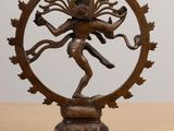 an image of a bronze statue of a person on a wooden table