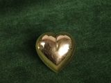 gold heart shaped brooch on a green velvet background