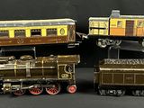 trois trains miniatures assis l'un à côté de l'autre sur une table