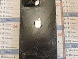 an apple iphone with a cracked screen sitting on top of a calendar