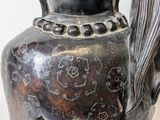 a vase with a bird on it sitting on a table