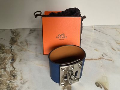 an orange and blue box with a silver buckle on a marble surface