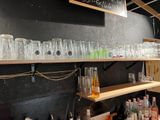 Des bouteilles et des verres sont alignés sur une étagère dans un magasin de spiritueux