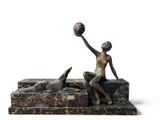 statue of a woman sitting on a bench with a ball in her hand