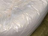 a mattress that is wrapped in plastic on a conveyor belt