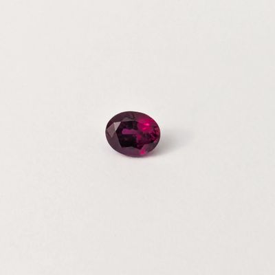 un gros plan d'une pierre précieuse violette sur une surface blanche