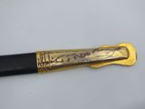 an image of a gold and black pen with writing on it