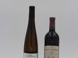 two bottles of wine sitting next to each other on a white surface