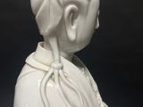 a white statue of a woman with a flower in her hair