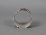 a close up of a silver ring on a gray surface