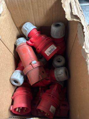 a cardboard box full of red and white electrical plugs