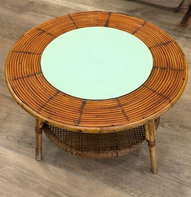 une table ronde avec un plateau en verre posée sur un parquet