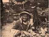 une vieille photo d'une femme vendant des légumes au marché