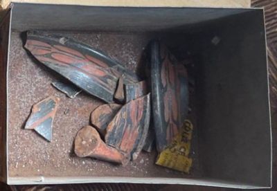 une boîte remplie de vieilles planches de skate posée par terre
