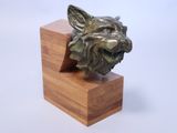 a bronze sculpture of a dog on a wooden block