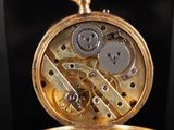 a close up of a gold pocket watch with gears on it