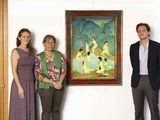 three people standing next to a painting in a room