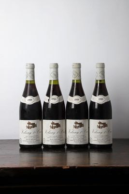 six bottles of wine are lined up on a wooden table