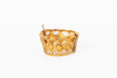 une image d'un bracelet en or sur fond blanc