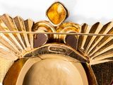 a gold plate with a hat on it and a gold broocher
