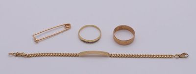 un bracelet en or, une bague et d'autres bijoux posés sur un fond blanc