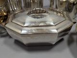 a silver plated tea set with four cups and a saucer
