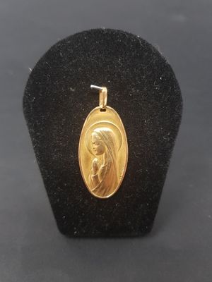 a gold plated pendant with a woman ' s face on it