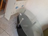 une table avec un plateau en verre, dans un coin de la pièce