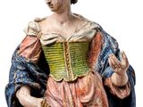 an old statue of a woman in a pink dress with a blue cape