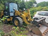 a bulldozer that is parked next to a white car