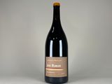 une bouteille de vin vide posée sur une surface blanche