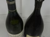 two bottles of wine sitting next to each other on a table