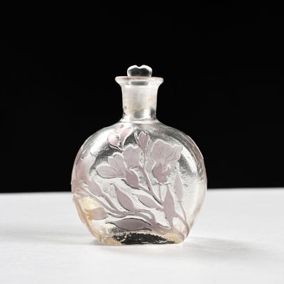 une petite bouteille en verre ornée d'un motif floral