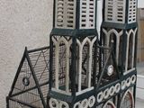 a small bird cage with a clock on top of it
