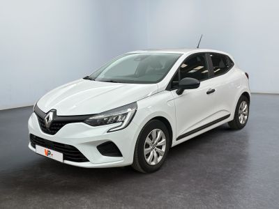 Une voiture blanche est garée dans une pièce au sol noir.