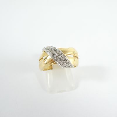 gros plan d'une bague en or avec des diamants sur une surface blanche