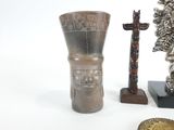 un vase en argent posé à côté d'une statue représentant un homme