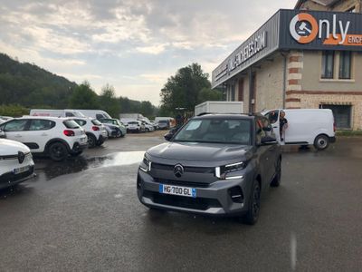 de nombreuses voitures garées sur un parking devant un immeuble