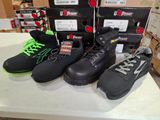 five pairs of shoes on a table with boxes in the background
