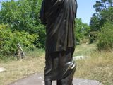 une statue représentant un homme debout dans l'herbe