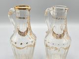 pair of clear glass vases with gold rims on a white surface