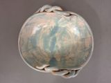 a blue and white bowl with a knot around it