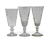 three clear glass goblets sitting next to each other on a white surface