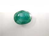 a close up of a green emerald stone on a white surface