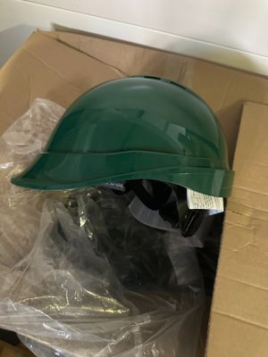 a green helmet sitting on top of a cardboard box