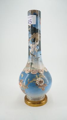 un vase bleu avec un socle doré sur fond blanc