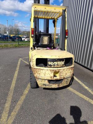un chariot élévateur jaune garé sur un parking