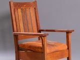 un vieux fauteuil à bascule en bois avec une assise en cuir sur fond gris