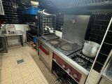 une cuisine équipée d'une cuisinière, d'un évier et d'un four